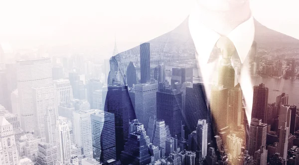 İş adamı çatıda duruyor ve arka planda şehir var.