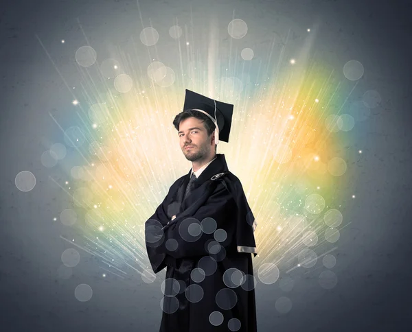 Happy graduate met kleurrijke moeras lichten op de achtergrond — Stockfoto