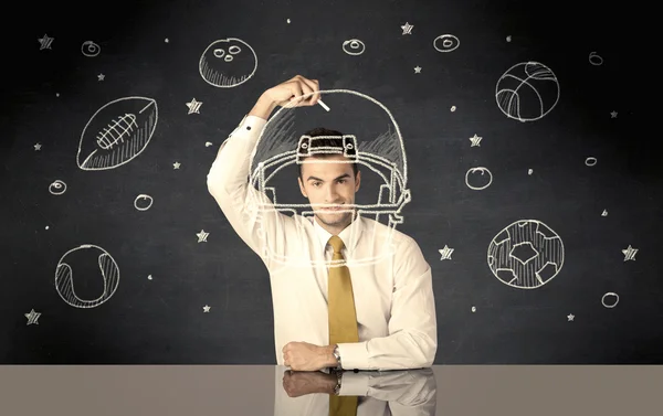 Бизнесмен рисует шлем и спортивные мячи — стоковое фото