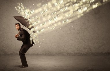 İş adamı dolar yağmuruna karşı şemsiye tutuyor