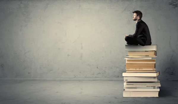 Étudiant assis sur une pile de livres — Photo