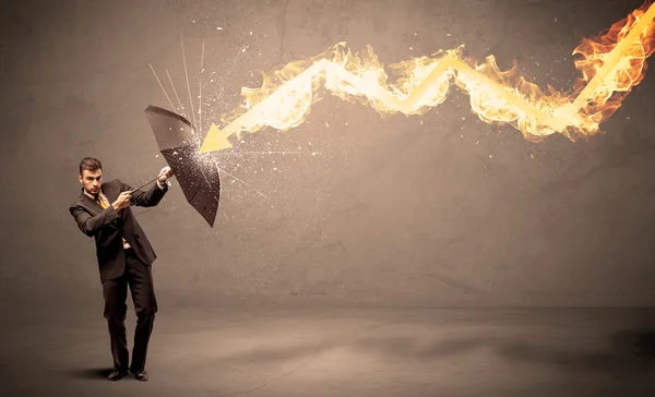 Hombre de negocios defendiéndose de una flecha de fuego con un paraguas — Foto de Stock
