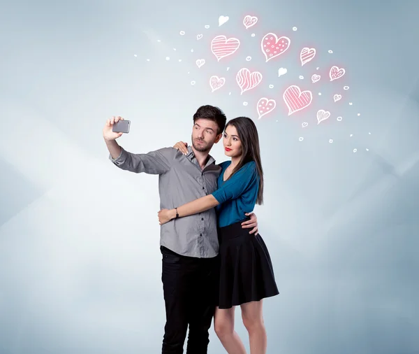 Couple in love taking selfie with red heart — Stock Photo, Image