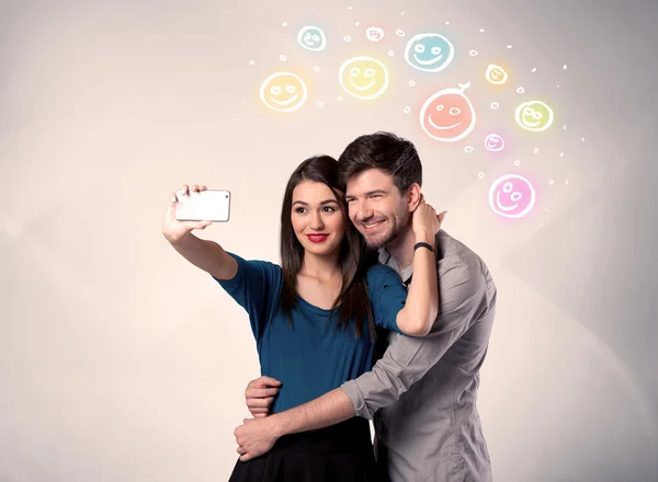 Pareja feliz tomando selfie con smiley —  Fotos de Stock