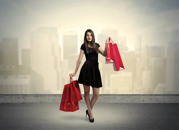 Město žena stojící s nákupními taškami — Stock fotografie