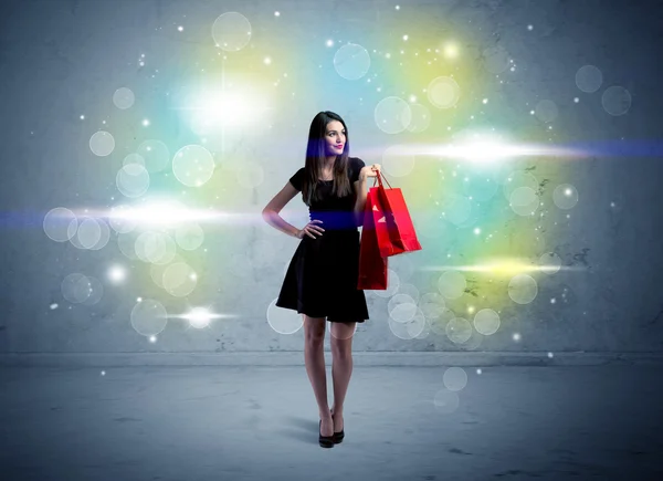 Senhora do shopping com sacos de compras e luz de brilho — Fotografia de Stock