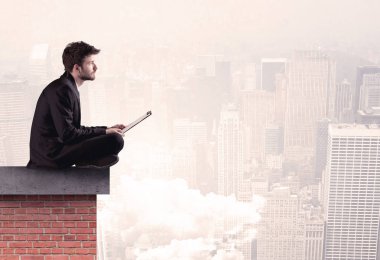 Şehirde çatıda oturan ofis çalışanı