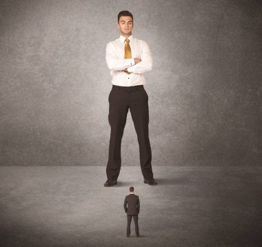 Büyük iş adamı küçük işçilere bakıyor.