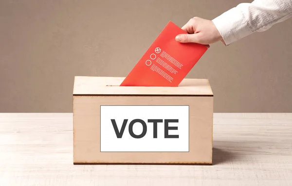 Fechar a mão masculina colocando voto em uma urna — Fotografia de Stock