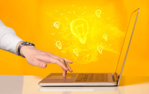 Close up of hand with laptop and  idea bulb — Stock Photo, Image