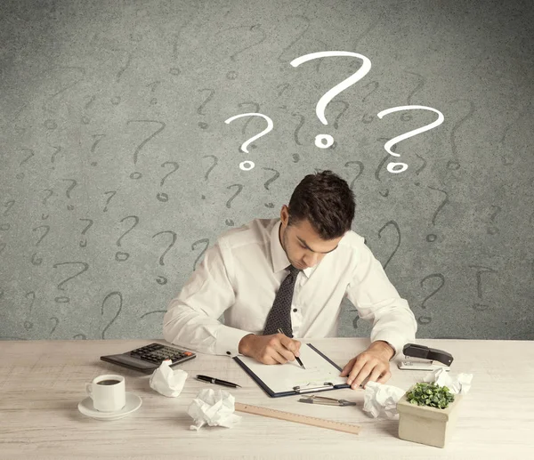 İş adamı soru işaretiyle masada.