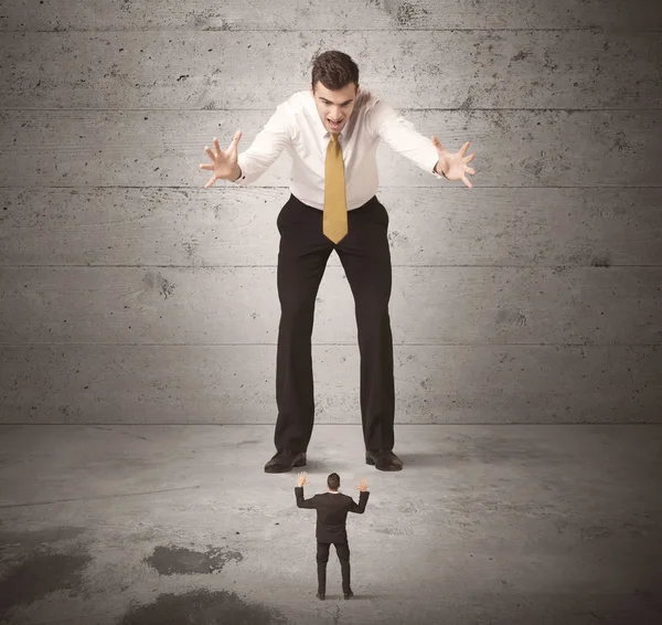 Büyük bir iş adamı küçük bir iş arkadaşına bakıyor.