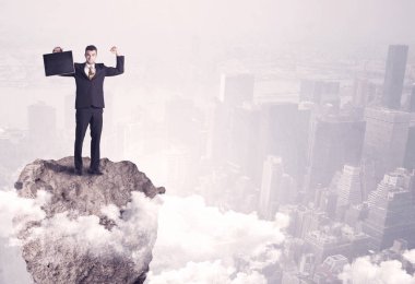 Kayanın üzerinde duran kazanan iş kişi