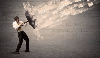 İş adamı ile şemsiye kağıtları rüzgara karşı koruma