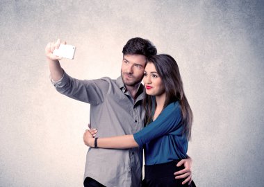Mutlu çift temiz duvarlı selfie çekiyor.