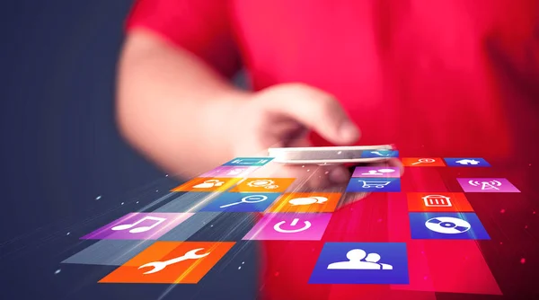 Hombre sosteniendo el teléfono inteligente con iconos de aplicación de colores —  Fotos de Stock