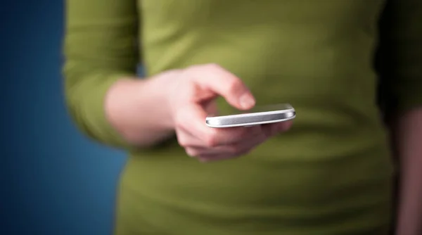 Jovem mulher segurando smarthphone na mão — Fotografia de Stock