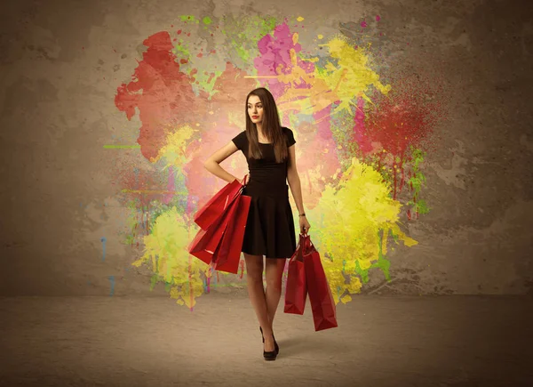 Девушка с пакетами для покупок и брызгами краски — стоковое фото