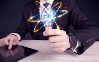 renkli bir ampul tutan işadamı