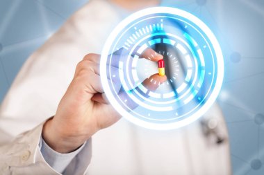 Erkek doktor elinde parlak halkaları olan bir hap tutuyor.