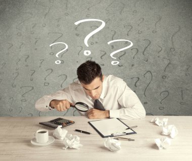 İş adamı soru işaretiyle masada.