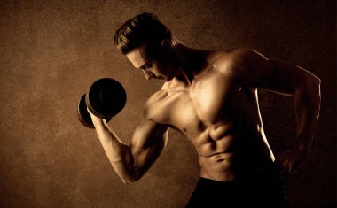 Kas formundaki vücut geliştirici sporcu ağırlık kaldırıyor 