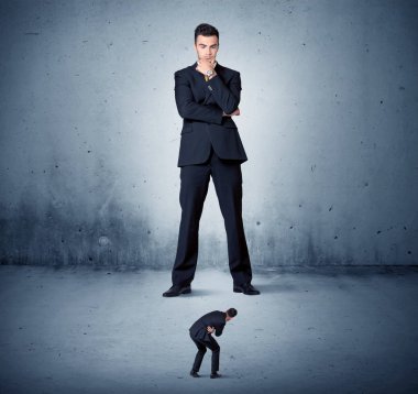 Öfkeli büyük iş adamı küçük adama lokma atıyor.