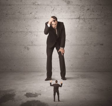 Büyük bir iş adamı küçük bir iş arkadaşına bakıyor.