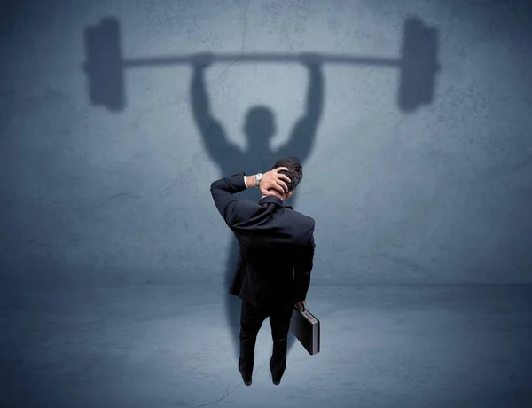 Businessman with weight lifting shadow — Stock Photo, Image