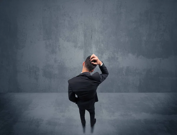 Businessman standing in front of urban wall — Stock Photo, Image