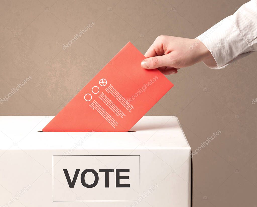 Close up of male hand putting vote into a ballot box