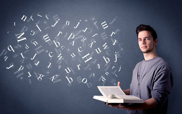 Young man holding book with letters — Stock Photo, Image