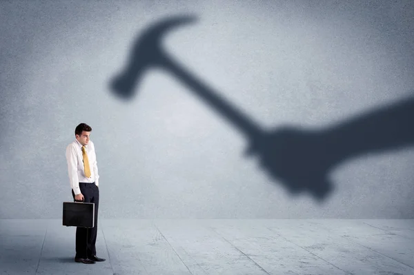 Business person afraid of a shadow hand holding hammer concept — Stock Photo, Image