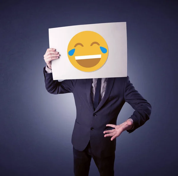 Geschäftsmann hält Papier mit lachendem Emoticon in der Hand — Stockfoto