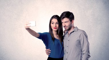 Mutlu çift temiz duvarlı selfie çekiyor.