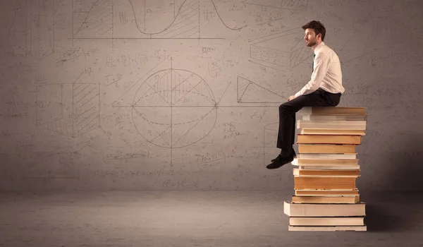 Businessman sitting on books — Stock Photo, Image