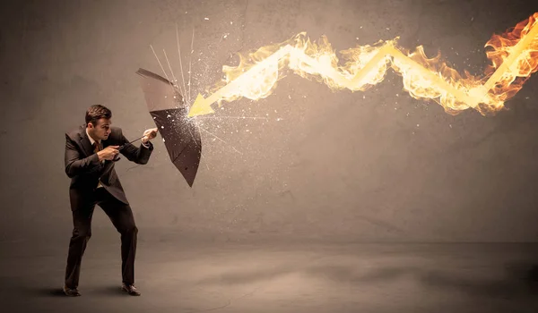 Homme d'affaires se défendant d'une flèche de feu avec un parapluie — Photo