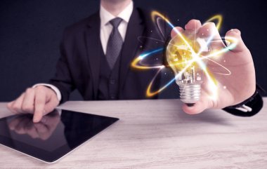 renkli bir ampul tutan işadamı