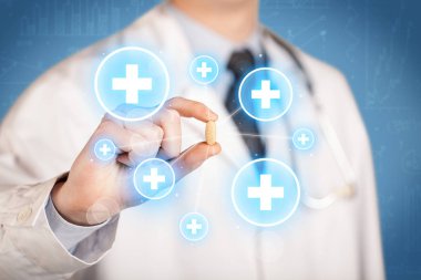 Haçlı bir hap gösteren bir doktor.