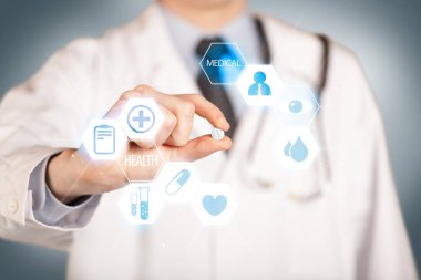 Beyazlı bir doktor elinde hap tutuyor.