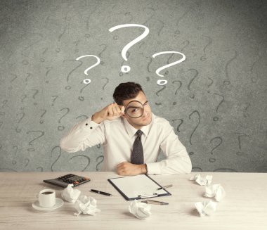 İş adamı soru işaretiyle masada.