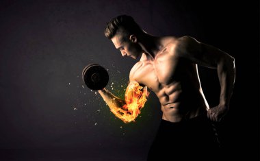 Vücut geliştirme sporcusu ateşli kol konseptiyle ağırlık kaldırıyor