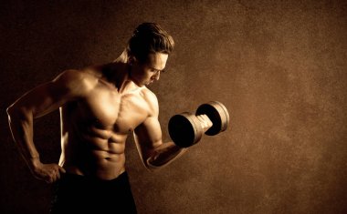 Kas formundaki vücut geliştirici sporcu ağırlık kaldırıyor 