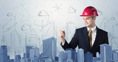 Genç işçi şehir manzarası çiziyor.