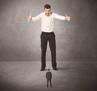 Büyük iş adamı küçük işçilere bakıyor.