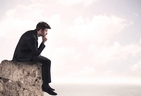 Hombre de negocios sentado en el borde de piedra — Foto de Stock