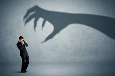 İş kişi büyük canavar pençe gölge kavramı korkuyor