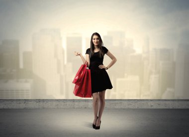 Alışveriş torbalarıyla duran şehir kadını.