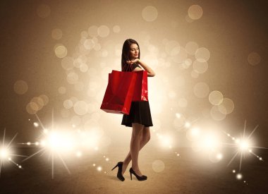 Parlak ışıklarda çantalı alışveriş yapan kadın.