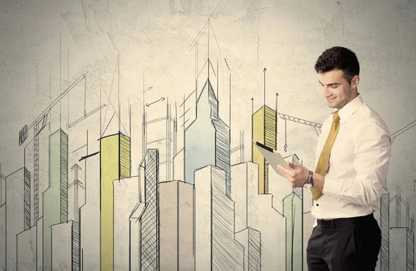 Businessman standing with drawn cityscape — Stock Photo, Image